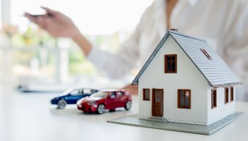 Car and House model with agent and customer discussing for contract to buy, get insurance or loan real estate or property background.