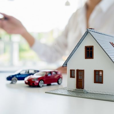 Car and House model with agent and customer discussing for contract to buy, get insurance or loan real estate or property background.