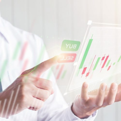Asian Business male using finger touching SELL button on digital virtual screen with candlestick graph, financial and investment concept
